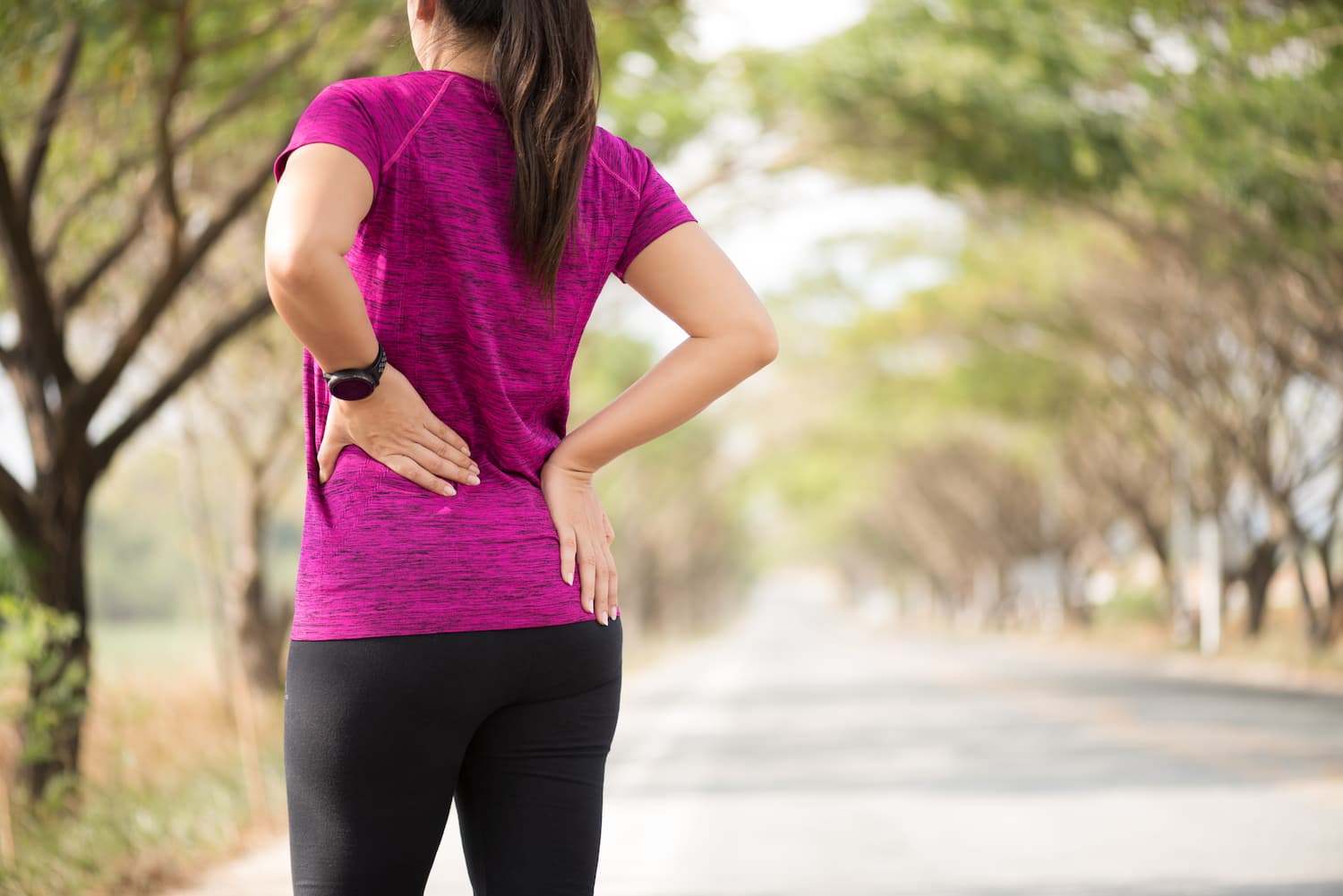Patient holding lower back with lumbar spine highlight for back pain treatment