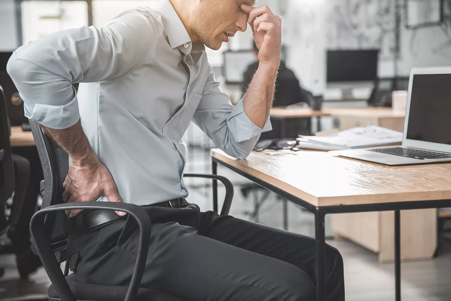 Patient with back discomfort seated in a chair