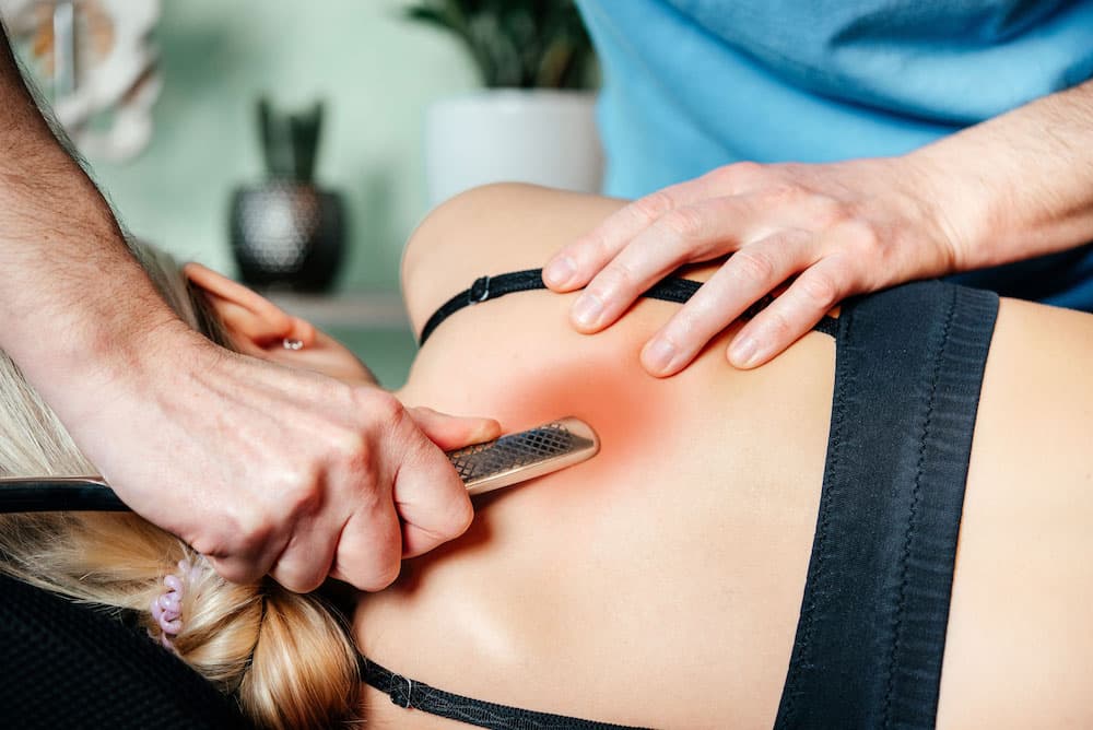 Clinician using a myofascial release tool during soft-tissue therapy